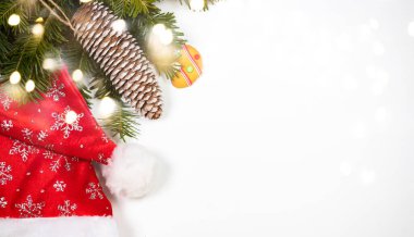 Christmas background with gingerbread cookies, Santa hat and pine tree branch on white.