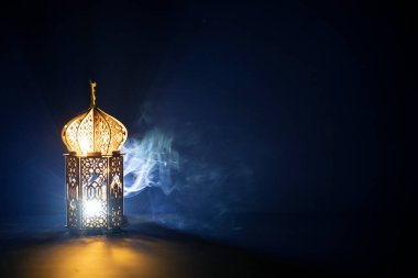 Süslü Arap feneri. Geceleri yanan mum ve parıldayan altın bokeh ışıkları. Müslüman kutsal ayı Ramazan Kareem için kutlama kartı.