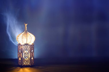 Süslü Arap feneri. Geceleri yanan mum ve parıldayan altın bokeh ışıkları. Müslüman kutsal ayı Ramazan Kareem için kutlama kartı.