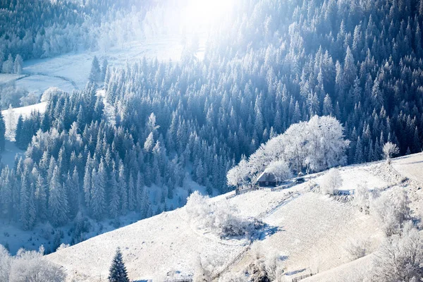 Fantastic winter landscape with wooden house in snowy mountains. Christmas holiday and winter vacations concept