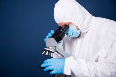 Koronavirüs aşısı geliştirmek için mikroskoba bakan bilim adamları farmasötik araştırma laboratuvarında.