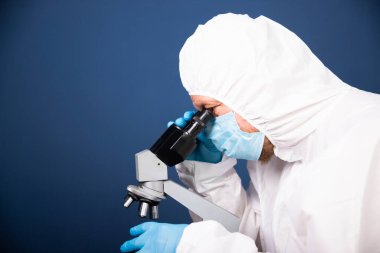 Koronavirüs aşısı geliştirmek için mikroskoba bakan bilim adamları farmasötik araştırma laboratuvarında.
