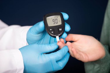 Doktor kan şekerini glukometreyle ölçüyor. Diyabet tedavisi kavramı.