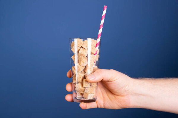 Стакан с кубиками сахара. Концепция опасной соды и безалкогольных напитков.