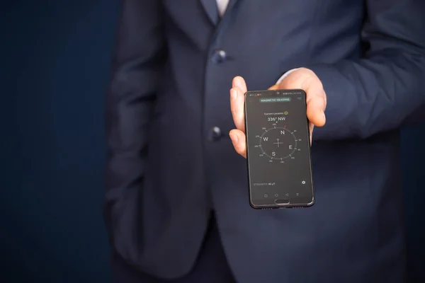 ビジネスマンはナビゲーションコンパス付きのスマートフォンを持っています 事業計画と戦略の成長 進捗または成功の概念 — ストック写真