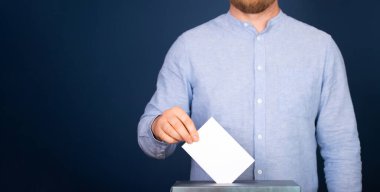 Oy sandığına oy veren bir seçmenin eli. Seçim kavramı.