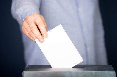 Oy sandığına oy veren bir seçmenin eli. Seçim kavramı.