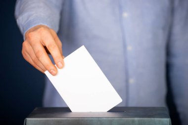 Oy sandığına oy veren bir seçmenin eli. Seçim kavramı.