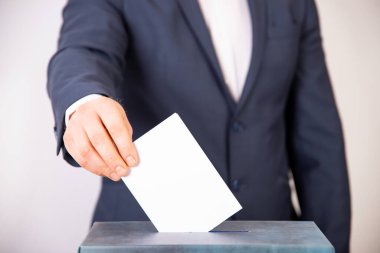 Oy sandığına oy veren bir seçmenin eli. Seçim kavramı.