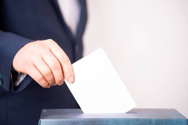 Oy sandığına oy veren bir seçmenin eli. Seçim kavramı.