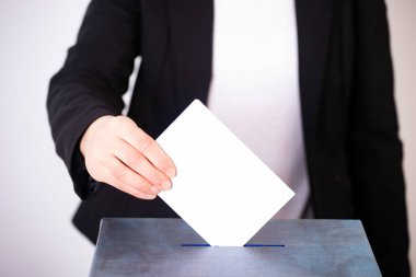 Oy sandığına oy veren bir seçmenin eli. Seçim kavramı.