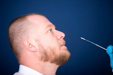 Korumalı ekipmanlı tıbbi personel hastaya Coronavirus genzinden örnek alıyor. Coronavirus konsepti için laboratuvar testleri.