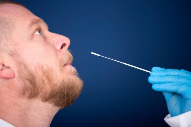 Korumalı ekipmanlı tıbbi personel hastaya Coronavirus genzinden örnek alıyor. Coronavirus konsepti için laboratuvar testleri.