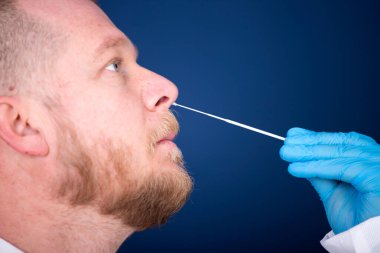 Korumalı ekipmanlı tıbbi personel hastaya Coronavirus genzinden örnek alıyor. Coronavirus konsepti için laboratuvar testleri.