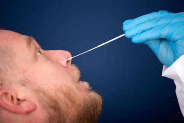 Korumalı ekipmanlı tıbbi personel hastaya Coronavirus genzinden örnek alıyor. Coronavirus konsepti için laboratuvar testleri.