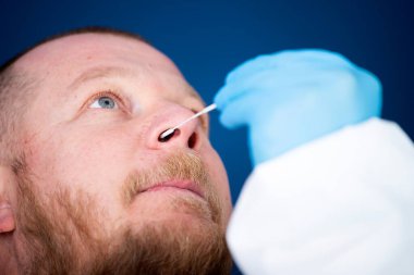 Korumalı ekipmanlı tıbbi personel hastaya Coronavirus genzinden örnek alıyor. Coronavirus konsepti için laboratuvar testleri.