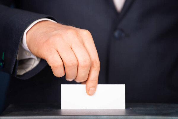 Избиратель ставит голосование в урну для голосования. Концепция выборов.