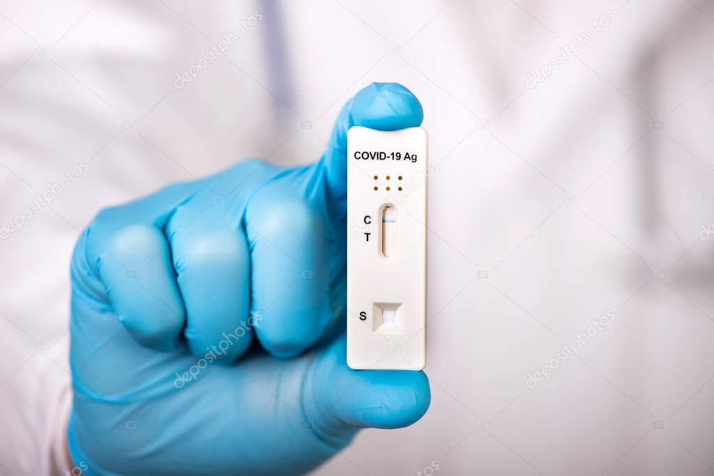 Doctor holding a test kit for viral disease COVID-19. Lab card kit tested NEGATIVE for viral novel coronavirus sars-cov-2 virus.