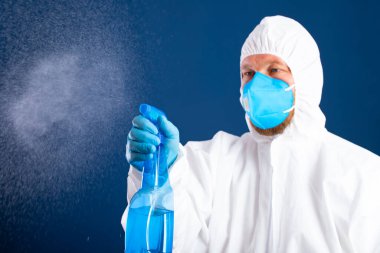 Konavirüs salgını. Salgını önlemek ve kontrol etmek için dezenfektanla korunan adam.. 