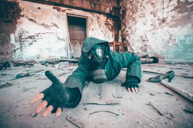 Gaz maskeli kıyametten kurtulan biri yıkılmış bir binada yardım istiyor. Çevre felaketi, mahşer kavramı.