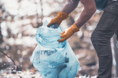Ormanı ya da parkları temizlemek için çöp plastiği topluyorum. Çevre Koruma, Dünya Günü, gönüllü konsept.