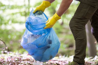 Ormanı ya da parkları temizlemek için çöp plastiği topluyorum. Çevre Koruma, Dünya Günü, gönüllü konsept.