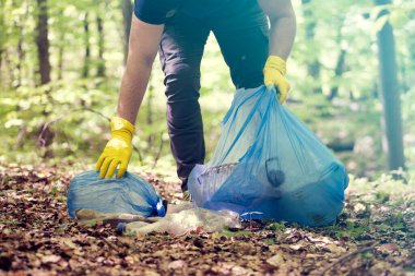 Ormanı ya da parkları temizlemek için çöp plastiği topluyorum. Çevre Koruma, Dünya Günü, gönüllü konsept.