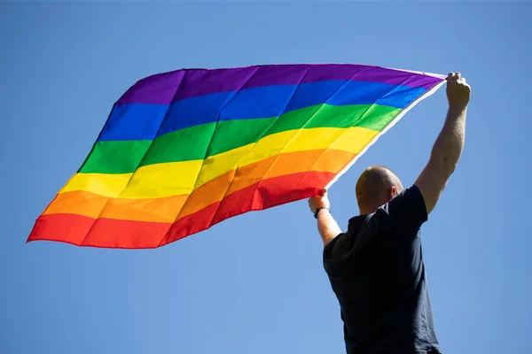Homem Segurando Uma Bandeira Arco Íris Gay Sobre Céu Azul — Fotografia de Stock