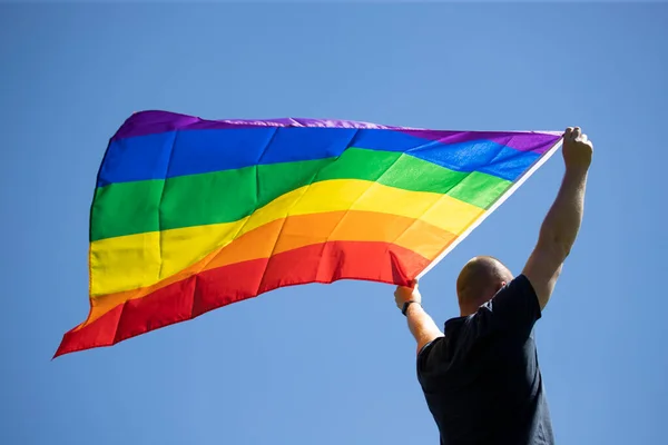 Hombre Sosteniendo Una Bandera Del Arco Iris Gay Sobre Cielo — Foto de Stock