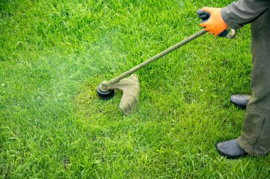Çim biçme makinesiyle çimleri biçmek. Bahçe işleri konsepti.