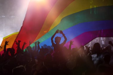 Onur topluluğunun elleri havada bir geçit töreni ve LGBT bayrağı - sevgi ve hoşgörünün sembolü