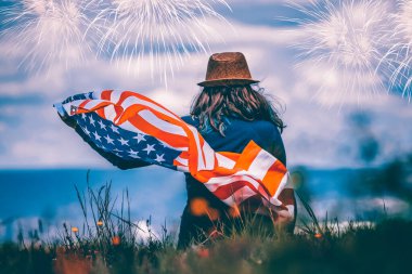 4 Temmuz 'da havai fişeklerin altında Amerikan bayrağını tutan mutlu vatansever genç kız.. 