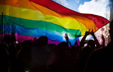 Onur topluluğunun elleri havada bir geçit töreni ve LGBT bayrağı - sevgi ve hoşgörünün sembolü