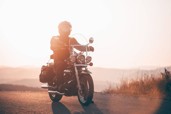 Motorcycle driver riding on countryside. Travel and sport, speed and freedom concept