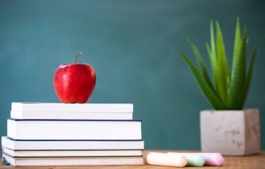 Okul Konseptine geri dönelim. Elma, aksesuarlar ve karatahtaya karşı kitaplar.