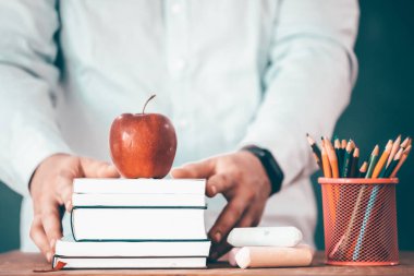 Okul konseptine geri dönelim: Öğretmen yeni okul sezonunun başında öğrencilerine kitap veriyor..