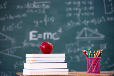 Okul Konseptine geri dönelim. Elma, aksesuarlar ve karatahtaya karşı kitaplar.