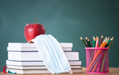 Coronavirüs salgınından sonra okula döndüm. Okul gereçleri, tıbbi maskeler, karatahta altyapısı. Öğrenme kavramı, sosyal mesafeyi koruma..