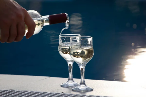 Summer party, wine in glasses near the swiming pool, summer drinks, relaxing by the water