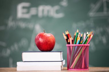 Okul Konseptine geri dönelim. Elma, aksesuarlar ve karatahtaya karşı kitaplar.