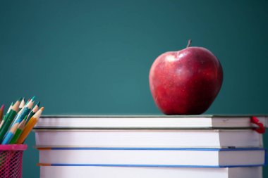 Okul Konseptine geri dönelim. Elma, aksesuarlar ve karatahtaya karşı kitaplar.