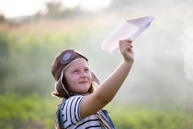 Pilot kaskıyla oynayan mutlu çocuk havacı gibi davranıyor. Seyahat, tatil ve özgürlük kavramı. Çocukluk, hayal gücü, hayal gücü.