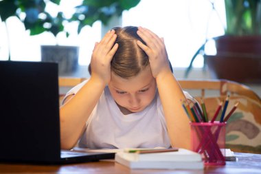 Uzaktan öğrenme, online eğitim. Liseli kız çevrimiçi eğitim dersleri izliyor ve okul ödevi yapıyor. COVID-19 salgını çocukları çevrimiçi öğrenmeye zorluyor.