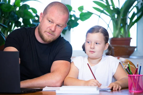 Distance learning concept. Father helps her daughter to do school homework, using digital tablet, e-learning concept, home education.