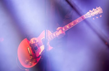 Yaz müzik festivalinde sahne ışıklarında gitarist