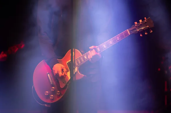 Guitarist in stage lights on summer music festival