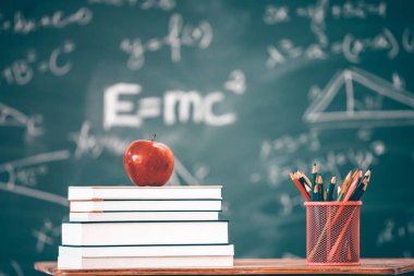 Okul Konseptine geri dönelim. Elma, aksesuarlar ve karatahtaya karşı kitaplar.
