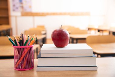 Okul Konseptine geri dönelim. Aksesuarlar ve kitaplar, arka planda bulanık sınıf.