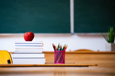 Okul Konseptine geri dönelim. Elma, aksesuarlar ve kitaplar sınıfta karatahtaya karşı..