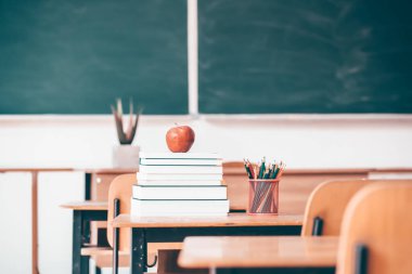 Okul Konseptine geri dönelim. Elma, aksesuarlar ve kitaplar sınıfta karatahtaya karşı..